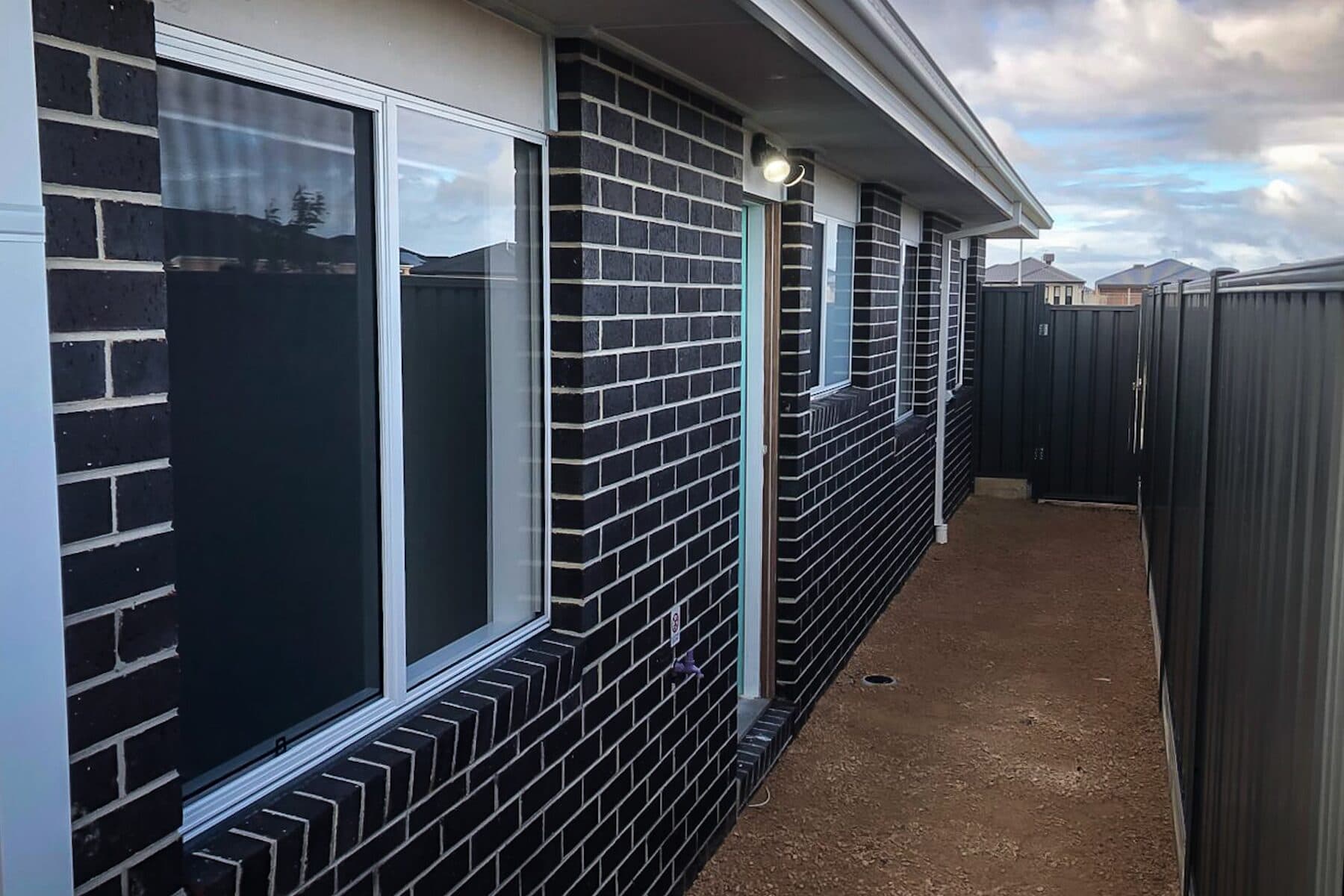 Charcoal face brick down the side passage of a new home